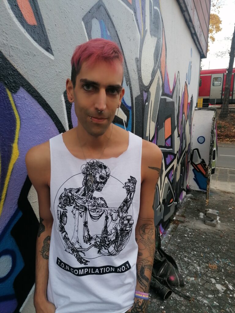 ph4nt. steht Trans of Noise-Shirt-tragend an einer Graffiti-übersähten Wand & guckt cute