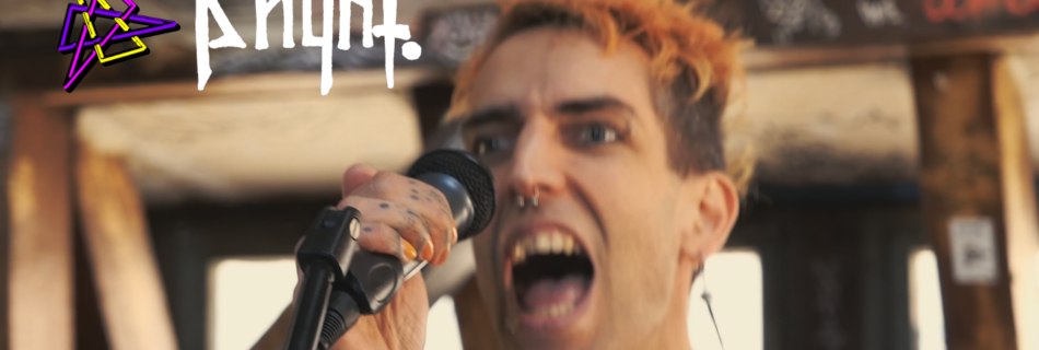 Screenshot aus dem Musikvideo zu [T]errorist*in: ph4nt. am Mikro, schreiend und mit orangenen Haaren. Nahaufnahme. Hintergrund sieht nach AZ aus.